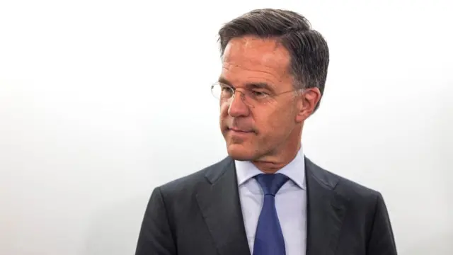 Mark Rutte in dark suit, white shirt and blue tie.