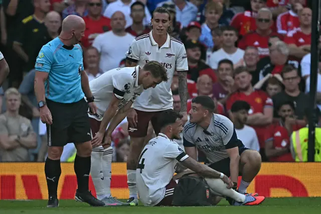 Ben White (C) reacts to picking up an injury