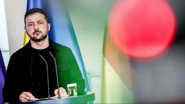 Ukrainian President Volodymyr Zelensky stood behind a podium.