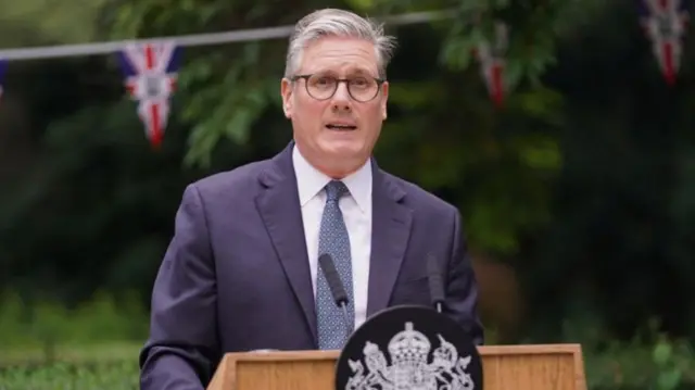 Starmer stood behind a podium.