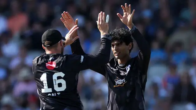 Rachin Ravindra of Manchester Originals celebrates with team mate Phil Salt after taking the wicket of Harry Brook