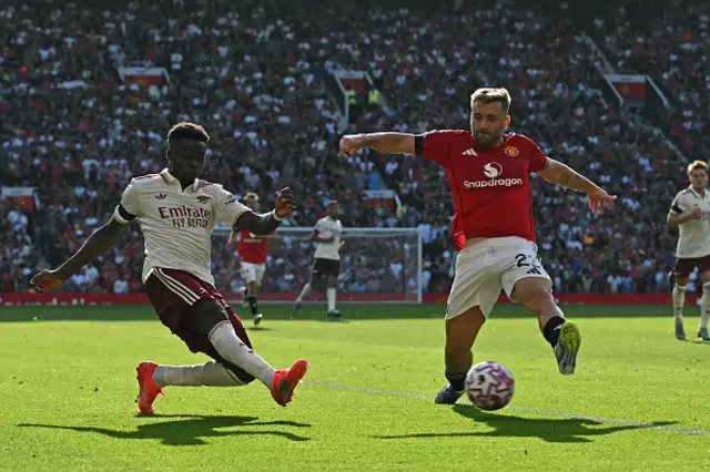 Bukayo Saka (L) crosses, under pressure