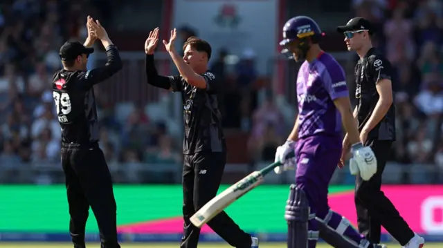 Sonny Baker of Manchester Originals celebrates with team mate Noor Ahmad after taking the wicket of Dawid Malan