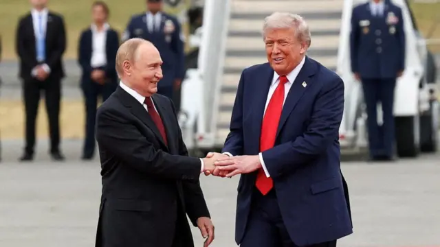 President Donald Trump shakes hand with Russian President Vladimir Putin, a plane behind them.