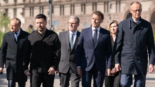 (left to right) Poland's Prime Minister Donald Tusk, Ukrainian President Volodymyr Zelensky, Prime Minister Sir Keir Starmer, French President Emmanuel Macron, Ukrainian President Volodymyr Zelensky's wife Olena Zelenska and German Chancellor Friedrich Merz in Maidan Square in Kyiv. They are mid-walking and all wear dark clothing