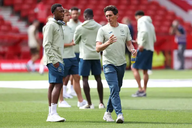 Brentford's Irish head coach Keith Andrews (R) speaks to players on the pitch