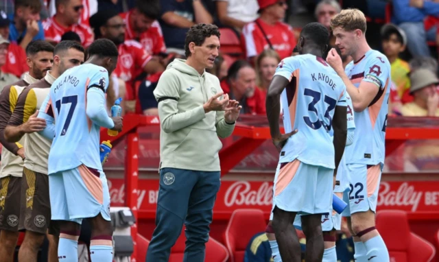 Brentford manager Keith Andrews talks to Michael Kayode and Nathan Collins