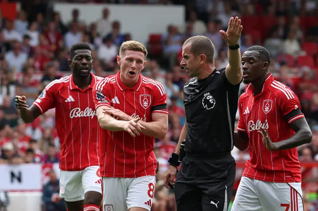 English referee Peter Bankes waves away Forest player's appeals for a handball