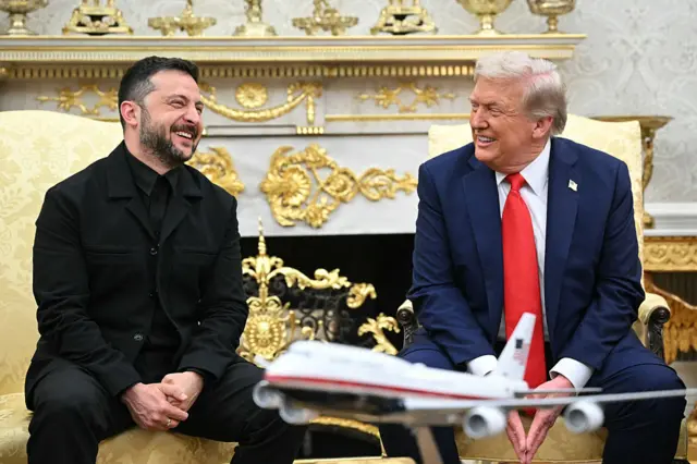 Ukrainian President Volodymyr Zelensky and US President Donald Trump laugh together in a meeting in the Oval Office