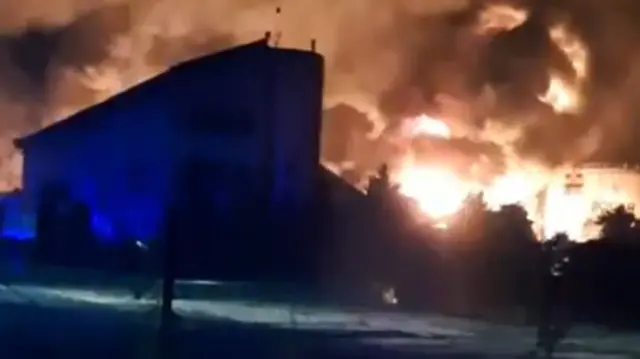 A screengrab from a verified video showing the night sky lit up by flames from the burning site