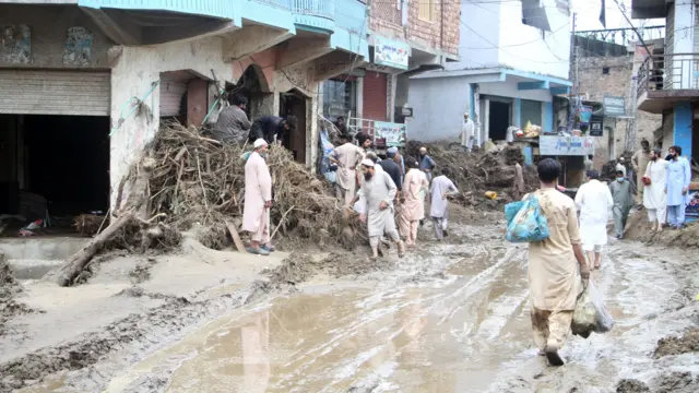 People removing debris from a street after flash floods