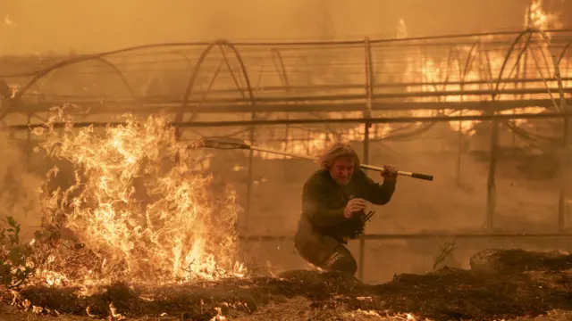 A firefighter next to a large fire