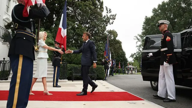 French President Emmanuel Macron (R) is greeted by US Chief of Protocol Monica Crowley