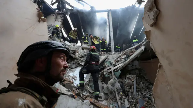 Rescuers at the site of a drone strike on a home in Kharkiv on 18 August