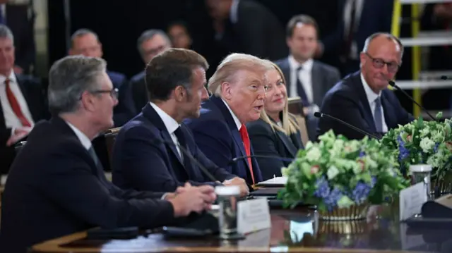 Keir Starmer, Emmanuel Macron, Trump, Giorgia Meloni and Friedrich Merz sit at a table in front of microphones