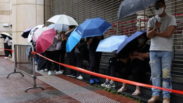 People queue to enter the West Kowloon Magistrates’ Courts building for the closing submissions in the national security collusion trial of Jimmy Lai