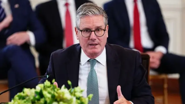 British Prime Minister Keir Starmer speaking, while wearing a suit and blue checked tie