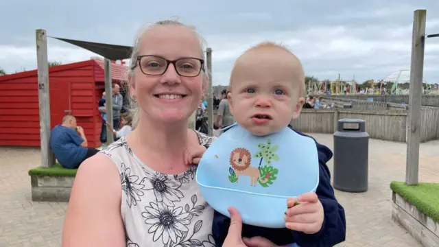 Michelle Birkenhead smiles while holding her infant son Roman Dudley