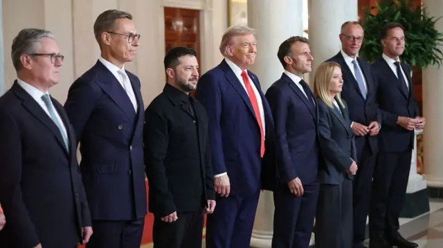 Leaders stand in a row at the White House to pose for a photo