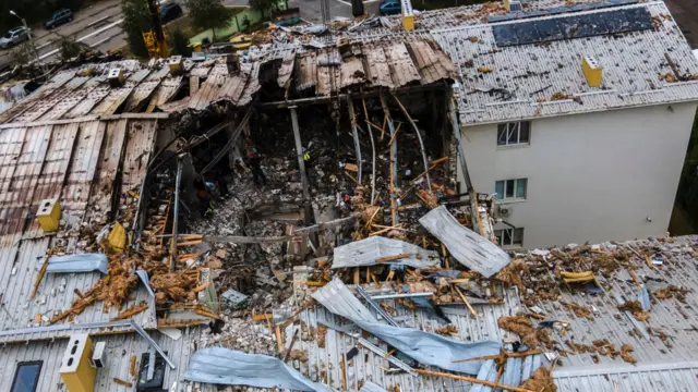 Ukrainian rescuers work at the site of a drone strike on a residential area in Kharkiv, north-eastern Ukraine