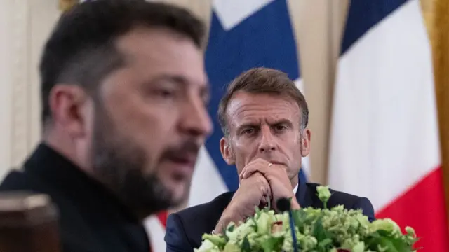 French President Emmanuel Macron looks on during a meeting with Ukrainian President Volodymyr Zelensky (L) and European leaders in the East Room of the White House in Washington, DC, on August 18, 2025