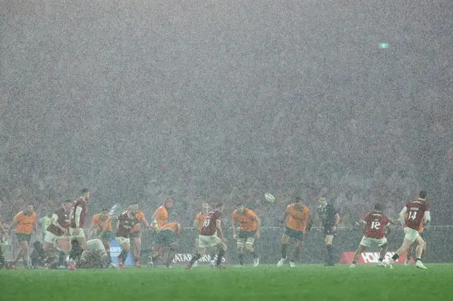 Australian and Lions players battle in the torrential rain