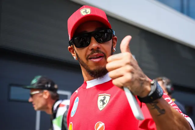 Lewis Hamilton gives a thumbs up in the paddock