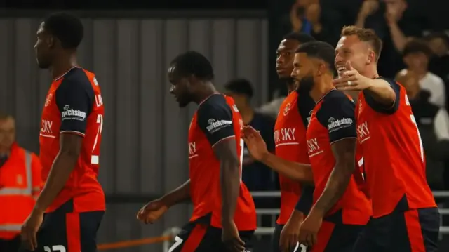 Luton players celebrate their winning goal against AFC Wimbledon