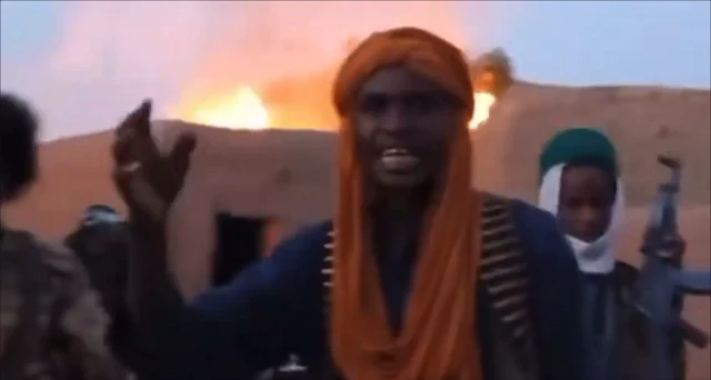 JNIM militants in front of burning buildings in the village centre.