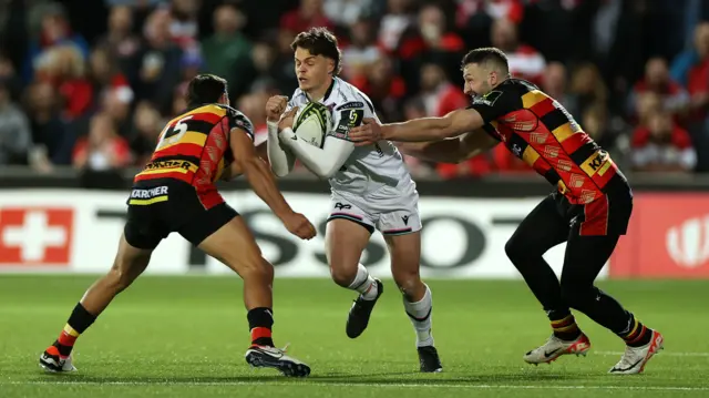 Jack Walsh of Ospreys is tackled by Santi Carreras and Jonny May of Gloucester