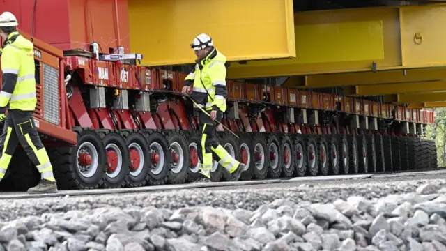 Workers check as the Kiruna Church landmark is being moved on a specially designed trolley with 224 wheels at a speed of half a kilometer per hour in Kiruna, northern Sweden, 19 August 202