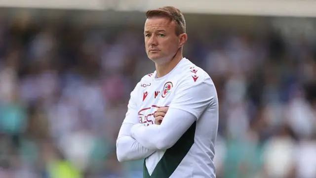 Noel Hunt looks on with his arms folded