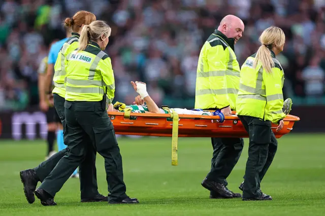 Alistair Johnston delivers a thumbs up to the fans as he comes off on a stretcher.