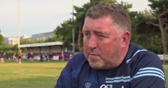 Emlyn Jones, pictured at Abersytwyth Rugby club, wearing a navy shirt. He has brown hair and looks at the camera.