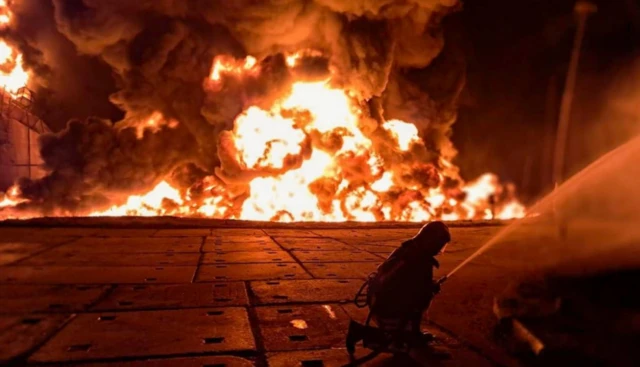 A firefighter in front of a large fire