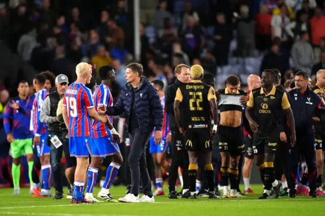 Players and staff shake hands on the pitch at full time