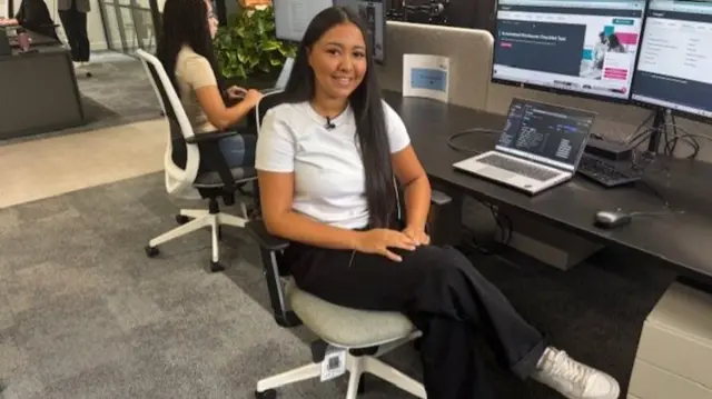 Young woman in smart casual clothing sat at office desk