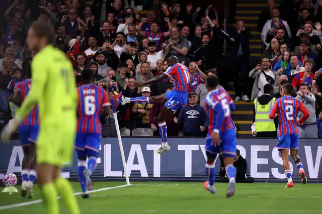 Mateta kicks the corner flag as his signature celebration as teammates run to join him