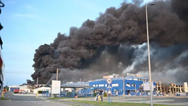 Heavy black smoke billowing above a group of buildings in Mukachevo, western Ukraine.