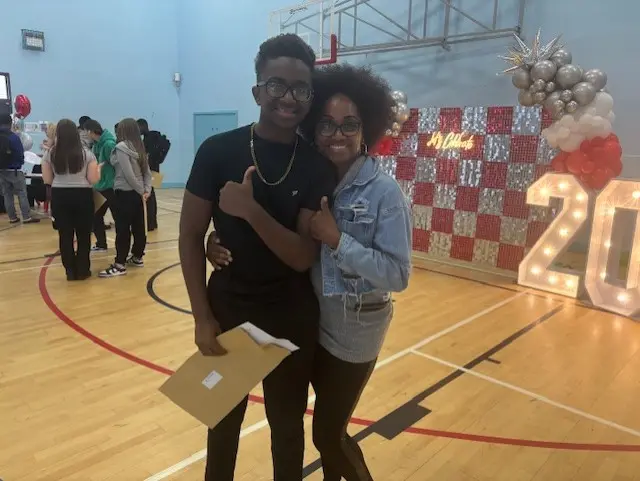 Sevante and his mum holding a thumbs up as they hold his results