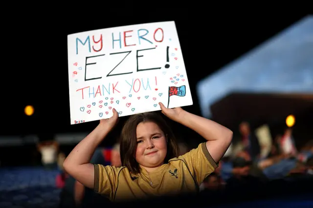 A fan holds up a sign that reads: 'My Hero Eze, Thank You'