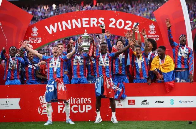 Joel Ward and Marc Guehi lift the FA Cup trophy in front of their teammates at Wembley