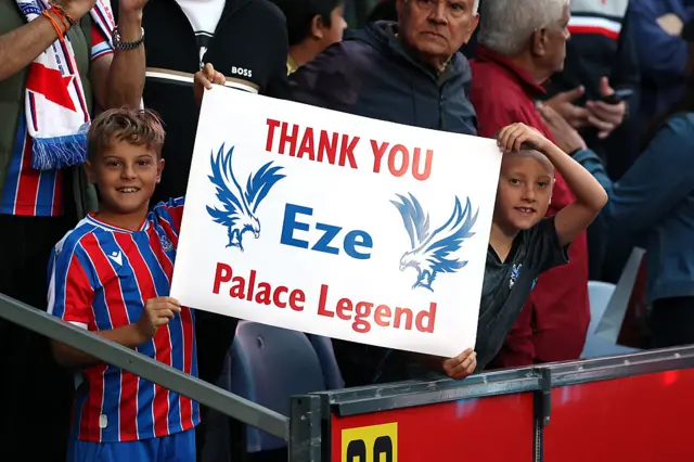 Fans hold up a thank you sign for Eberechi Eze