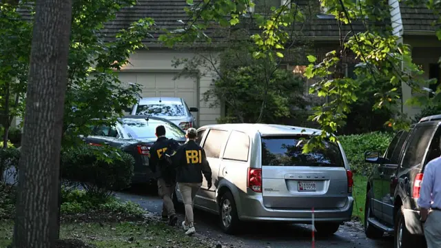 FBI agents walk outside John Bolton's house, Donald Trump's former national security advisor