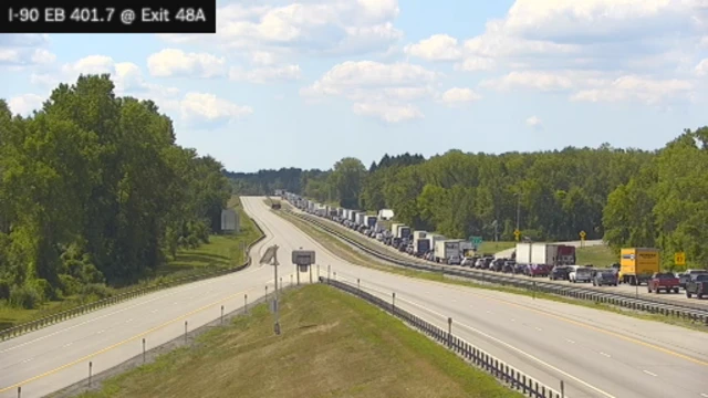 A traffic camera showing a long line of cars and trucks