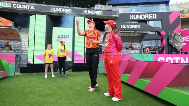 Ellyse Perry of Birmingham Phoenix tosses the tosses the coin ahead of alongside Tammy Beaumont of Welsh Fire