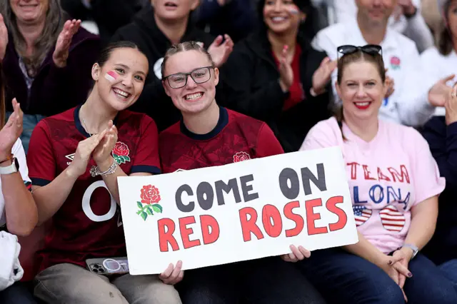 Fans holding a sign saying Go on red roses