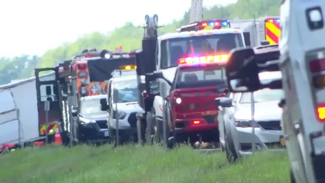 Several emergency vehicles parked up in a long line by a road