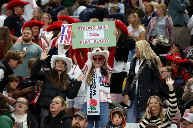 A fan holding a sign saying strong girls play rugby