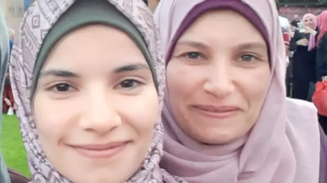 Aseel and another woman smiling to the camera